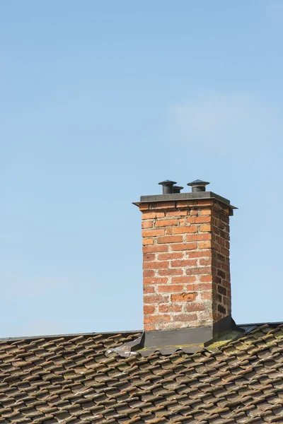 Chimenea de ladrillo rojo en el techo de la casa vieja —  Fotos de Stock