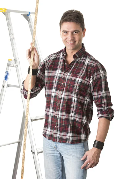 Male builder measuring with wooden rule — Stock Photo, Image