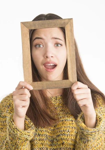 Attractive young woman holding wooden frame — Stock Photo, Image