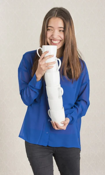 Attrayant jeune femme équilibrant une pile de tasses — Photo