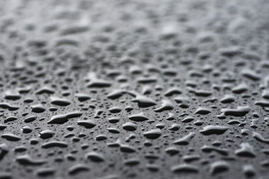 Yağmur damlaları siyah metal yüzeyi