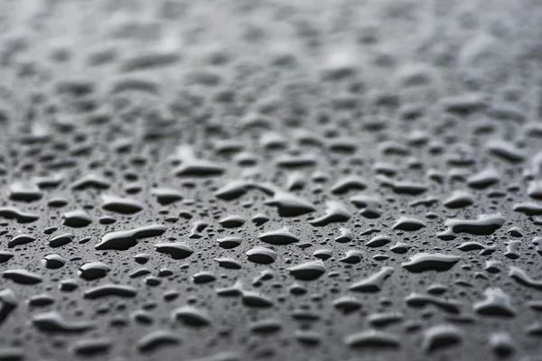 Raindrops on black metal surface — Stock Photo, Image