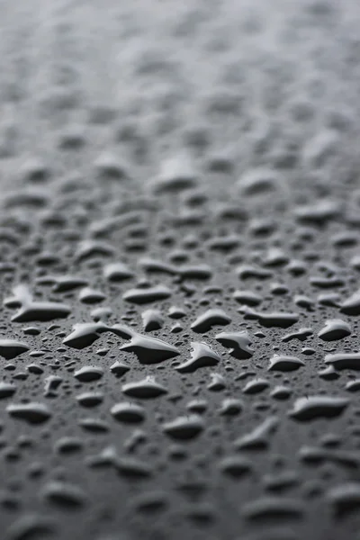 Raindrops on black metal surface — Stock Photo, Image