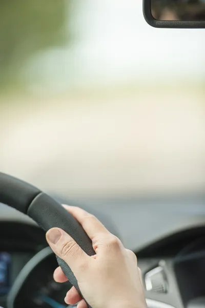 Mano de mujer en el volante dentro del coche Imagen de stock