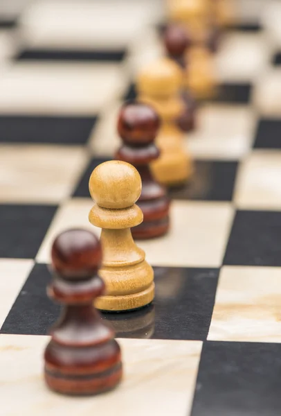 Piezas de ajedrez blancas y negras en un tablero de ajedrez —  Fotos de Stock