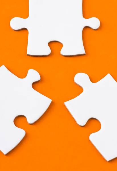 Pièces de puzzle blanc sur fond orange — Photo