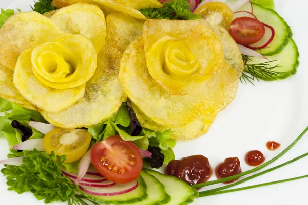 Batatas fritas na forma de uma rosa em uma chapa com uma salada Fotos De Bancos De Imagens