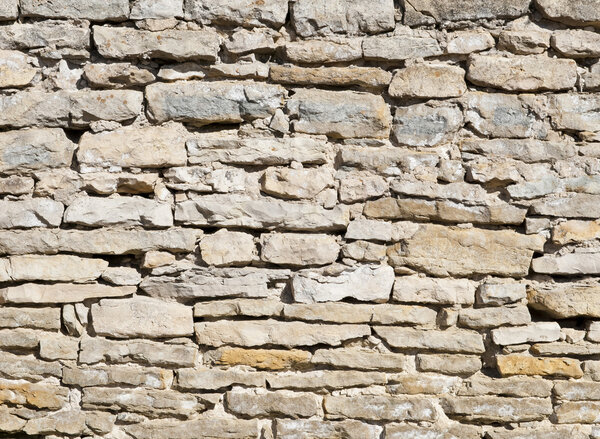 Limestone wall on a bright sunny day as background