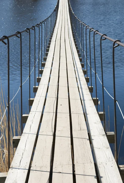 Ponte sospeso attraverso il fiume in una luminosa giornata di sole — Foto Stock