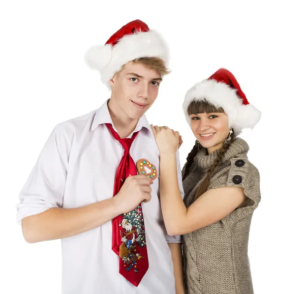 Smiling girl and the guy in red santa caps and gingerbread heart — Stock Photo, Image