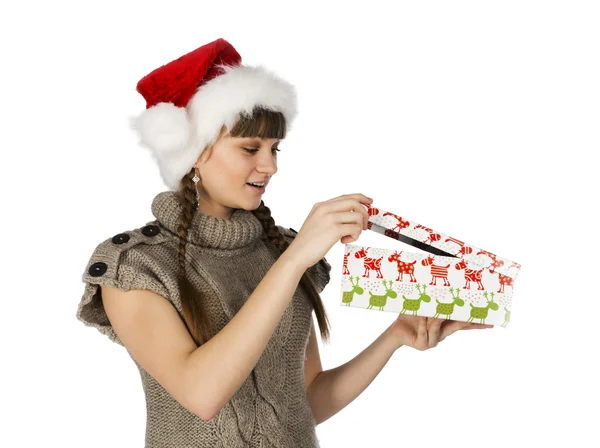Удивлённая девушка в красной кепке Санта-Клауса и подарок в руках — стоковое фото