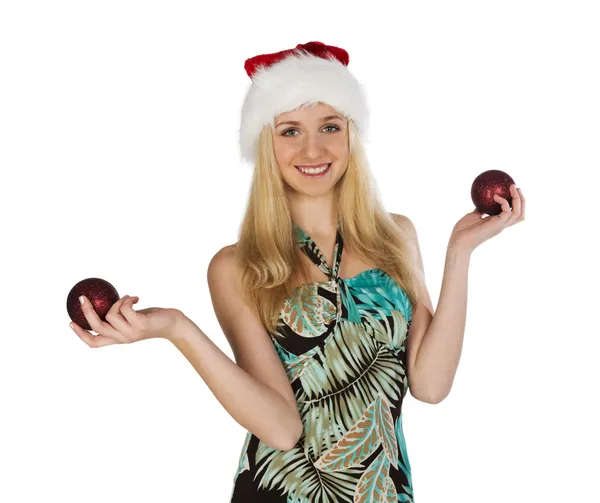 Girl in red christmas hat holds red fir-tree spheres in hand on — Stock Photo, Image