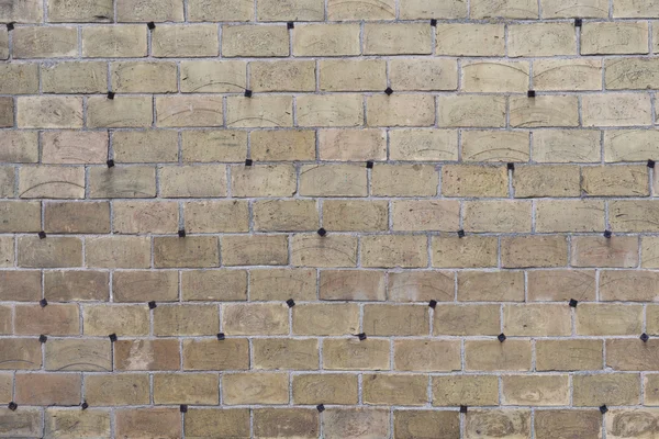 La pared de ladrillo gris creativo con remaches de hierro fundido como fondo —  Fotos de Stock