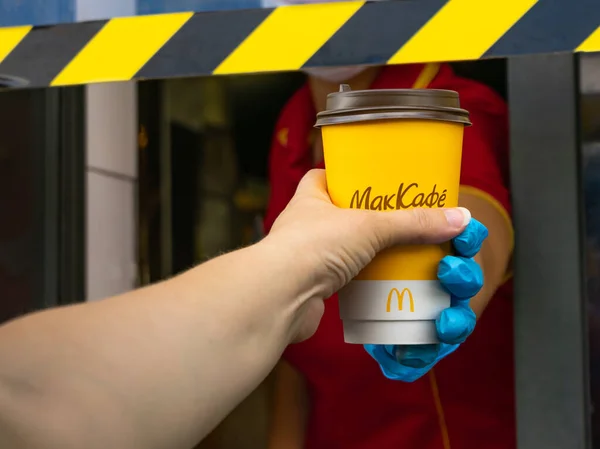 2021年7月29日，俄罗斯贝尔哥罗德。一个坐在车里的女人从麦当劳的送货窗口拿起黄色杯子里的咖啡。四.后续行动. — 图库照片