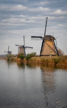 Hollanda, Kinderdijk 'te nehir kıyısında üç rüzgar değirmeni.