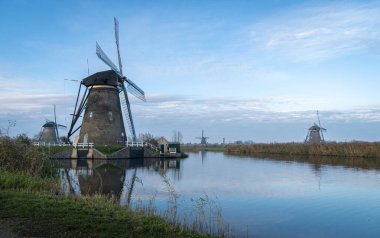 Hollanda Kinderdijk 'te kanalın kenarında antik yel değirmenleri