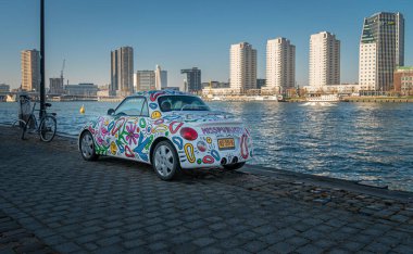 Rıhtımda renkli bir araba, arka planda gökdelenler, Rotterdam, Hollanda