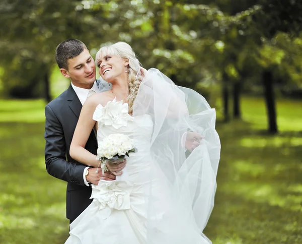 Noiva e noivo abraçar uns aos outros e rindo em seu casamento — Fotografia de Stock