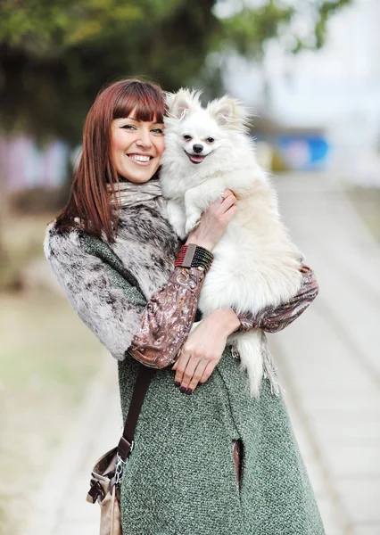 Mladá krásná žena drží její malé štěně a s úsměvem outd — Stock fotografie