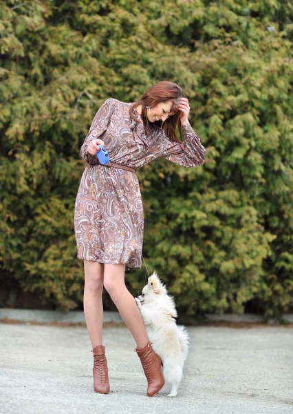 Portrait of a young happy female walking with her puppy — Stock Photo, Image