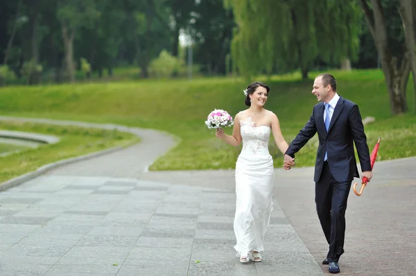 Mariée et marié s'amusent dans un parc — Photo