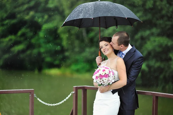 An excited wedding couple in a rainy day — Stock Photo, Image