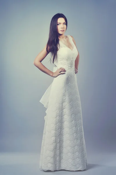 Beautiful girl in a wedding dress - full length portrait in stud — Stock Photo, Image