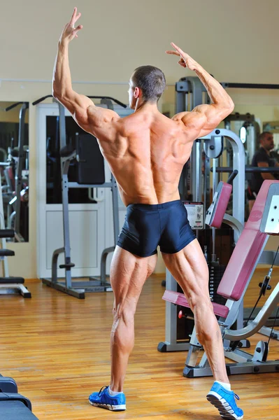 Kroppsbyggare som poserar vid gym - bakifrån full längd porträtt — Stockfoto