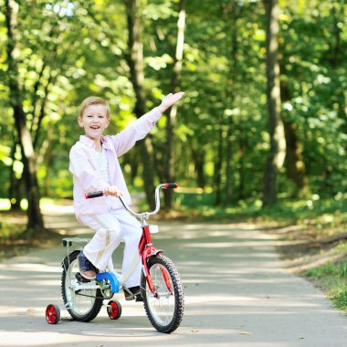 gülen ve copysp işaret eden bisiklet ile sevimli çocuk portresi