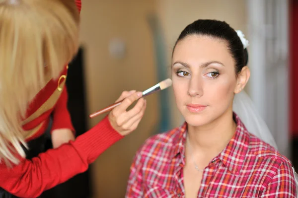 Maquillaje artista en acción en la cara hermosa mujer — Foto de Stock