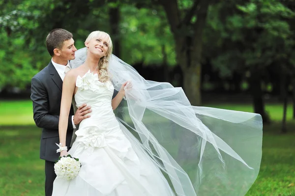 Bruden och brudgummen i en park. glad bröllop par — Stockfoto