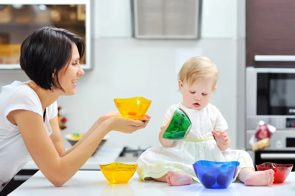 Little girl holding pepper on a kitchen — Stock Photo, Image