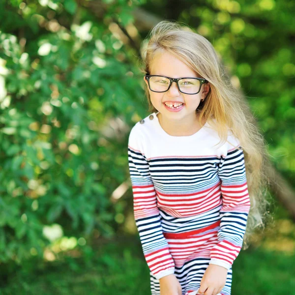 Bonne petite fille souriant dans un parc — Photo