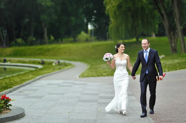 Wedding couple walking in a park — Stock Photo, Image