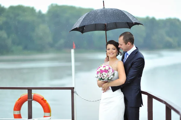 Bride and groom in a rainy weather — Stock Photo, Image