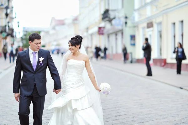 Bride and groom walking together in an old town — Stock Photo, Image