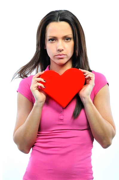 Retrato de estudio de una joven sosteniendo un corazón contra su che Imagen De Stock