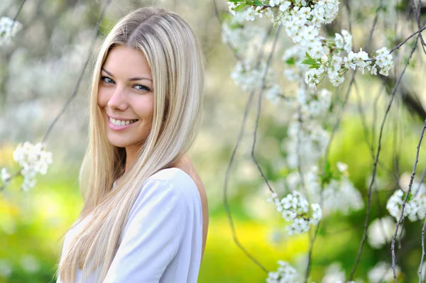Portrait of attractive beautiful blonde woman in green blooming — Stock Photo, Image
