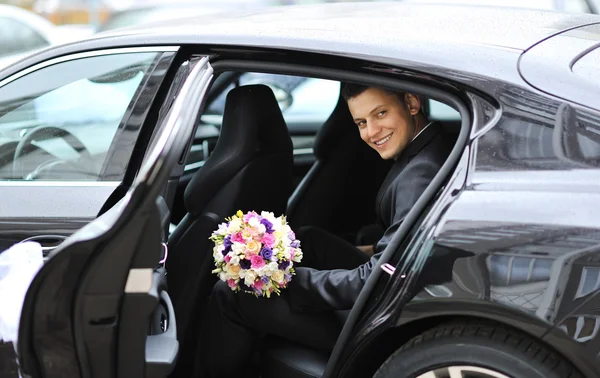 年轻英俊的新郎在婚礼当天坐在一辆车 — 图库照片
