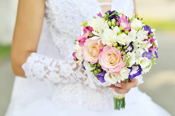 Bruid houdt een bruiloft boeket — Stockfoto