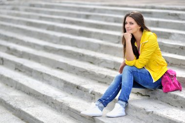 Parlak elbiseleri merdiven looki üzerinde oturmuş, bir moda kız