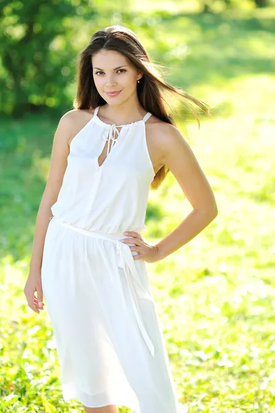 Hermosa chica sonriente mirándote contra la espalda verde primavera —  Fotos de Stock