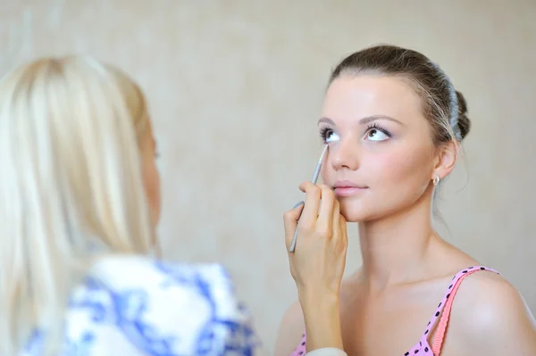 Giovane bella sposa applicare il trucco di nozze da make-up artist — Foto Stock