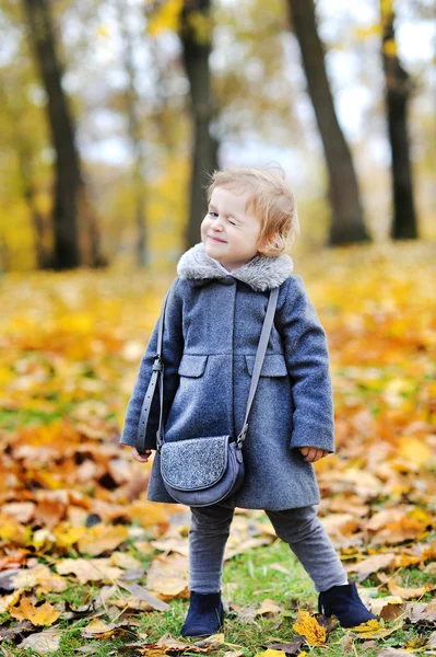 Cute little girl winks - full length outdoors portrait — Stock Photo, Image