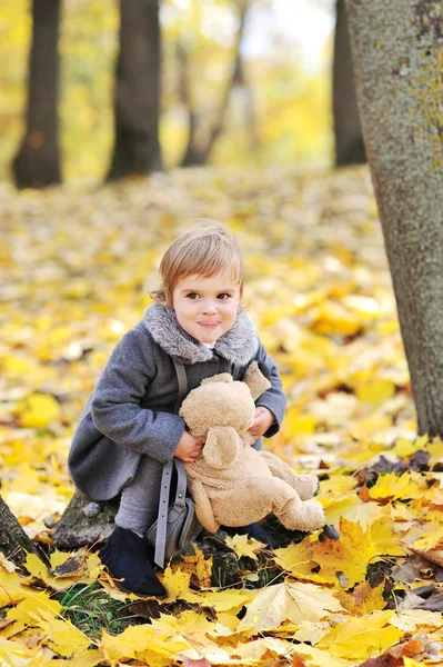 Roztomilá holčička hraje s její hračku v parku — Stock fotografie