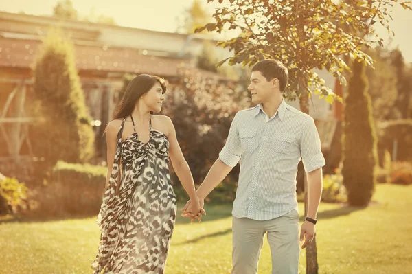 Giovane bella coppia a piedi in un parco estivo — Foto Stock