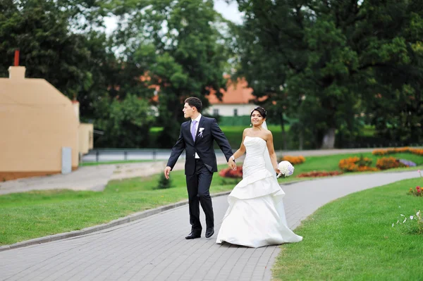 Bride and groom walking in an old town — Stock Photo, Image