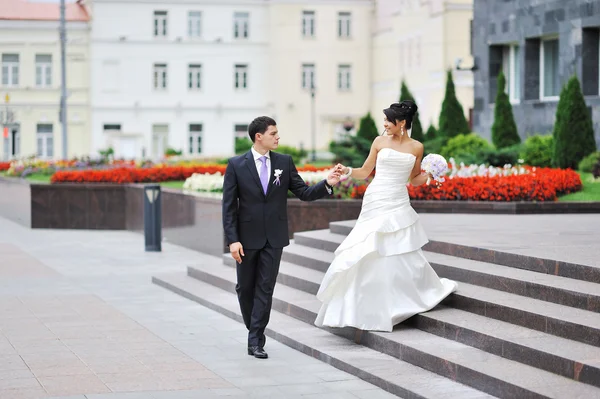 Bride and groom walking in an old town — Stock Photo, Image