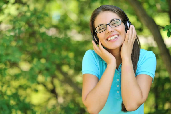 Ontspannen vrouw luisteren naar muziek in een park met ogen dicht — Stockfoto