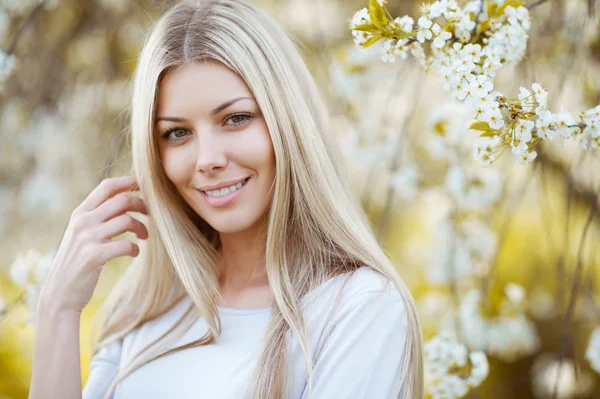 Foto di bella donna bionda in albero in fiore — Foto Stock